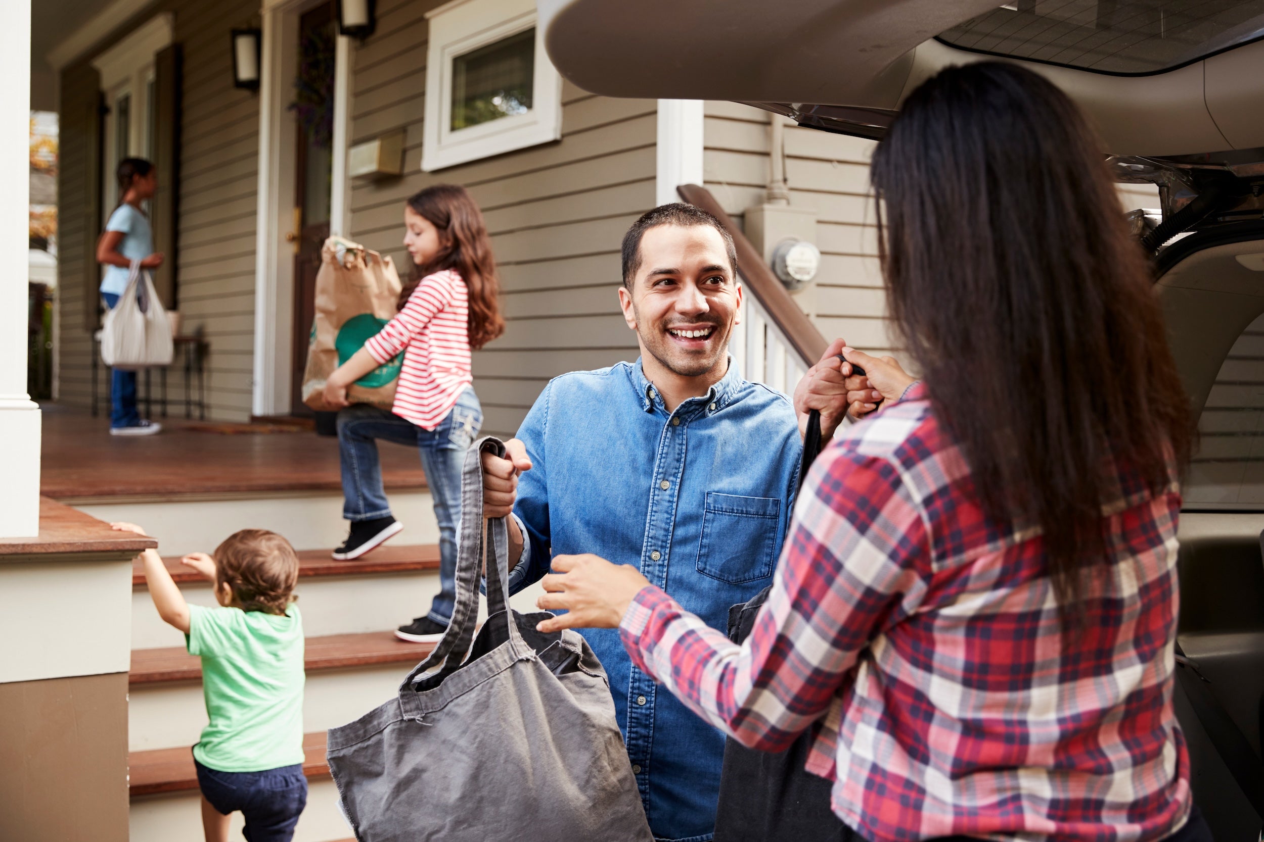Family unloading groceries from car